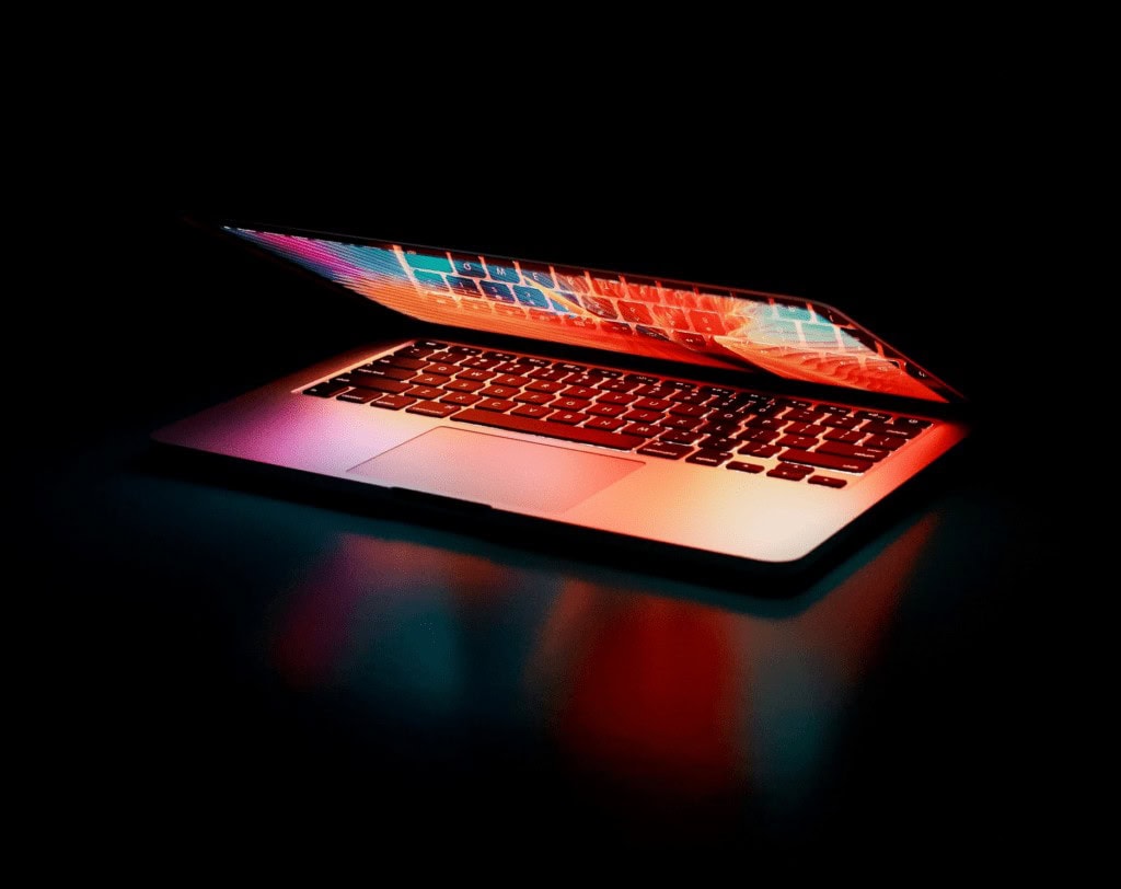 Partially closed laptop on a dark background