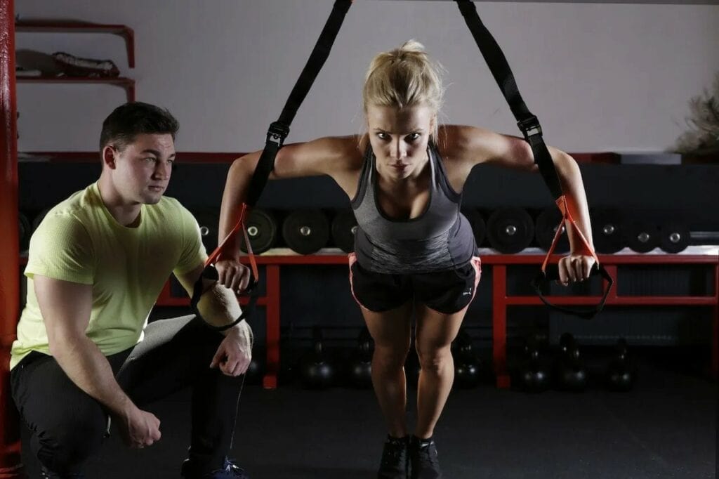 A Personal Trainer coaching his client in the weight room